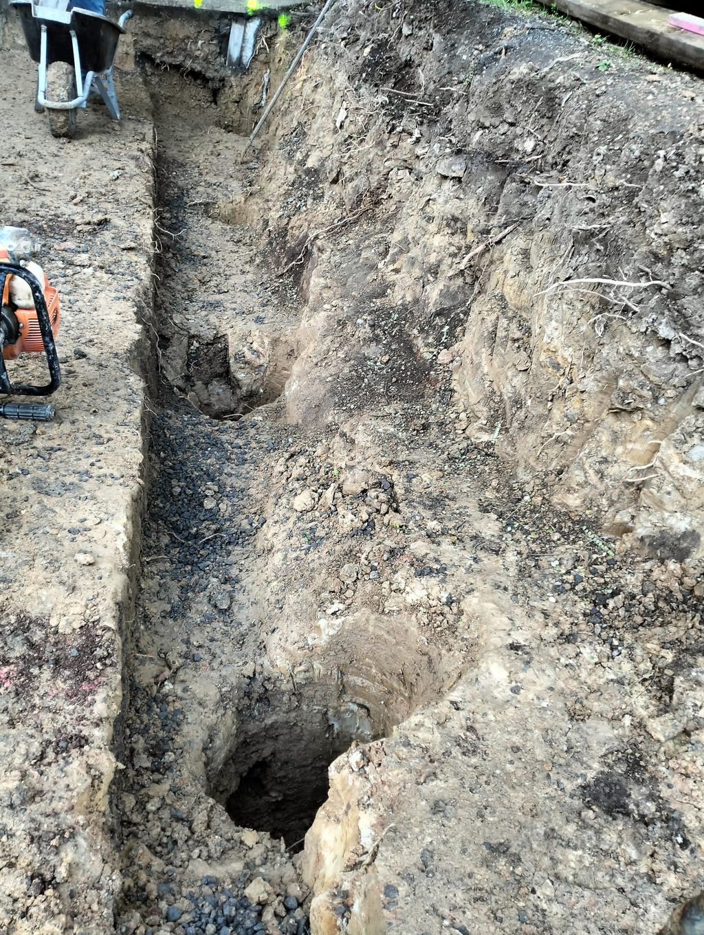 Close view of a narrow trench and excavated hole